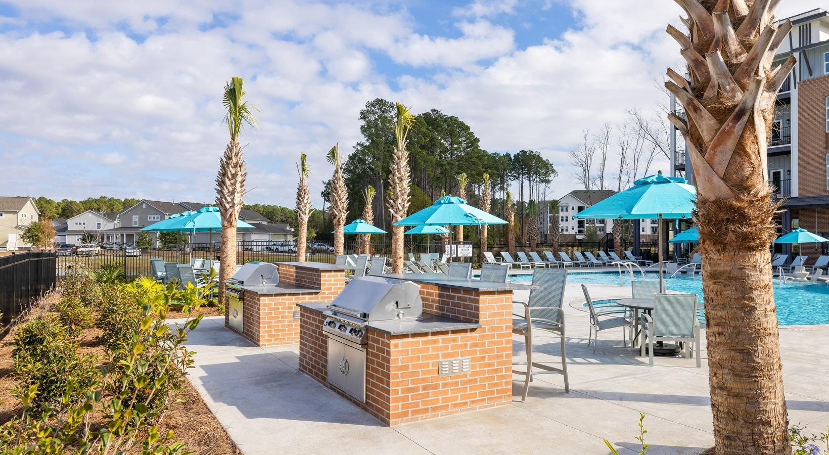 Relax and unwind poolside a pool with chairs and umbrellas