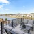 a deck with chairs and a table with a view of a lake and trees