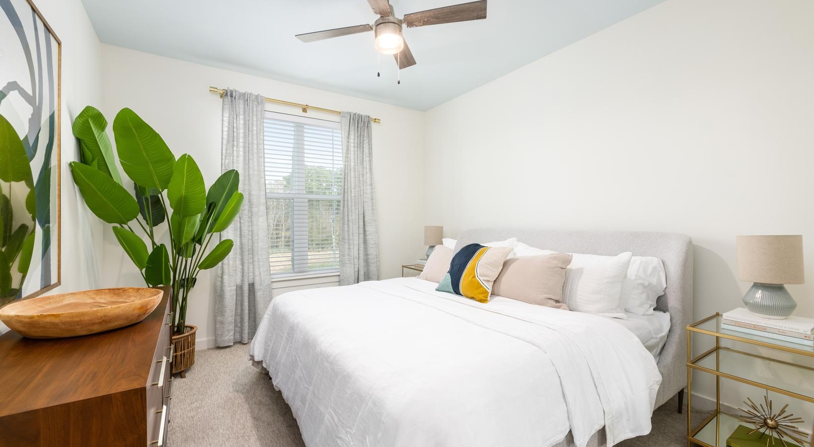 Relax and recharge in beautiful and spacious bedrooms a bedroom with a bed and a fan