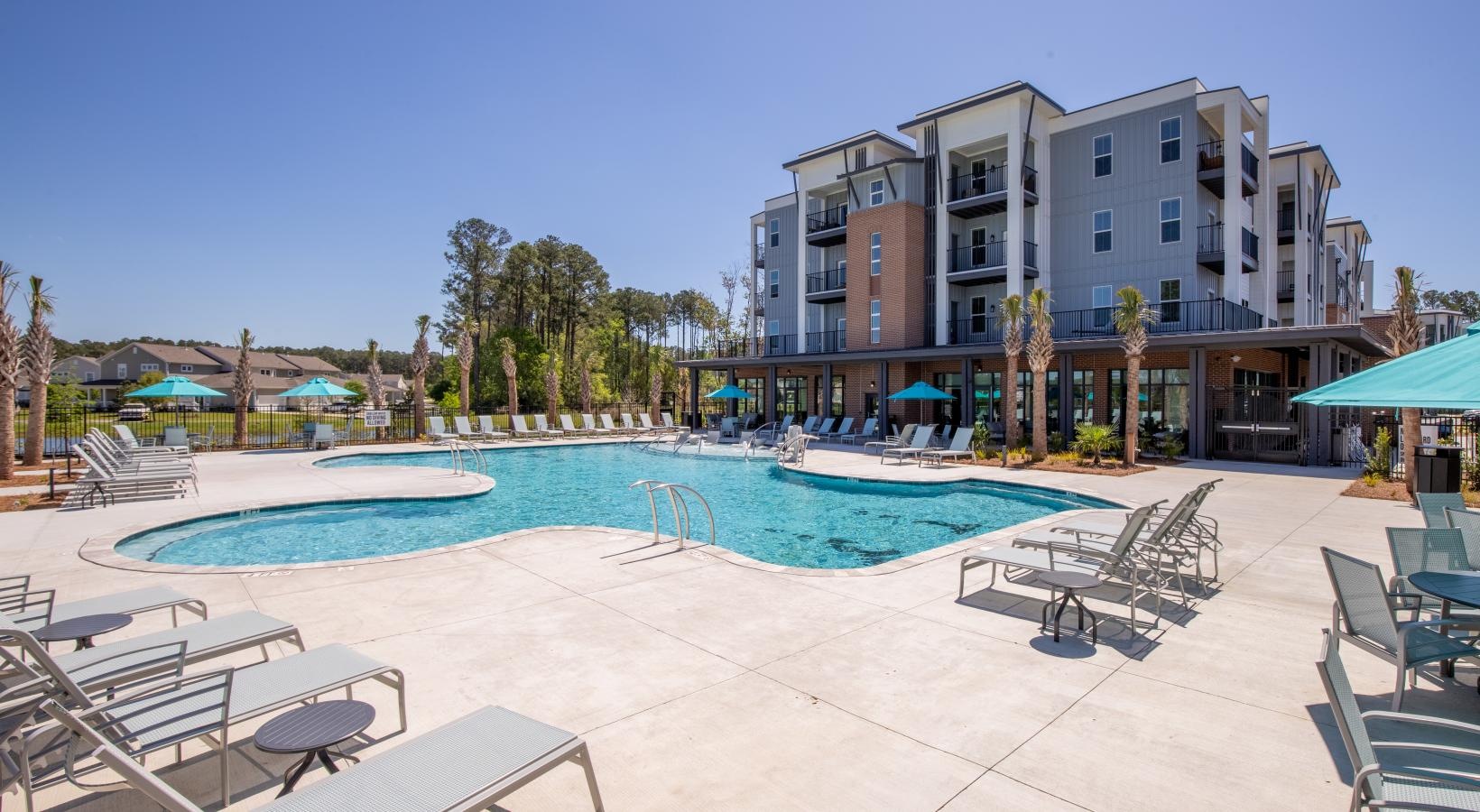 Relax and unwind poolside a swimming pool in front of a large building