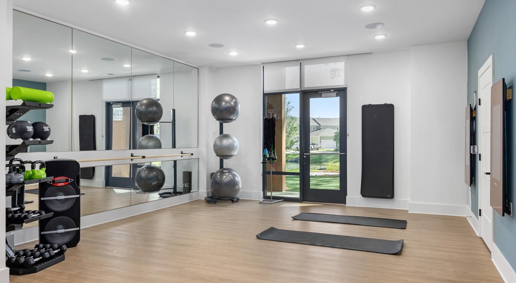 State-of-the-art amenities a room with a wood floor and a large mirror