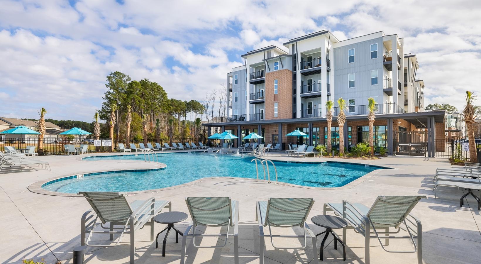 Relax and unwind poolside a pool with chairs around it